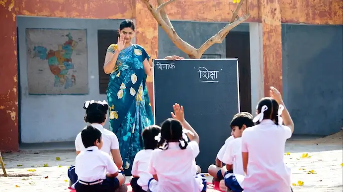 A volunteer teaching children in a village school courtyard